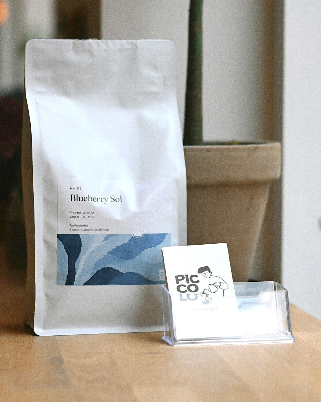 Blueberry Sol pose fra Peru med Piccolo visitkort på bordet i espressobaren i Vejle